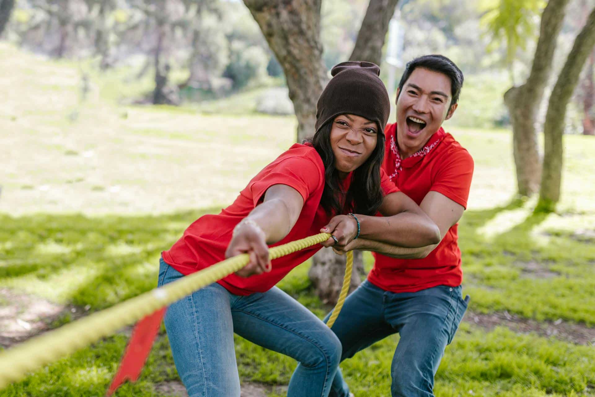 Two team members in red pull on one side of a tug-of-war rope