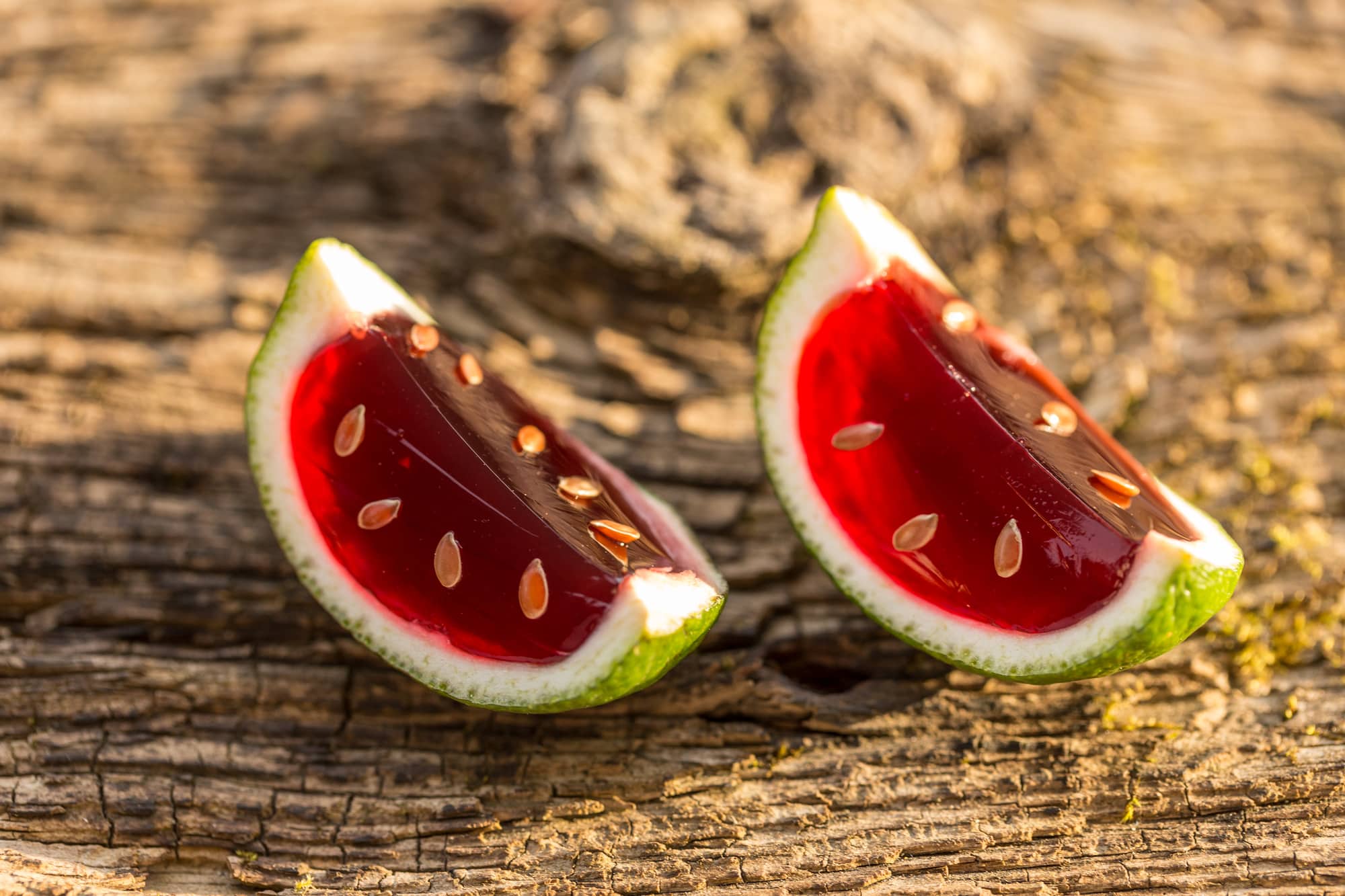 Strawberry jello in lime peel on vintage wooden background