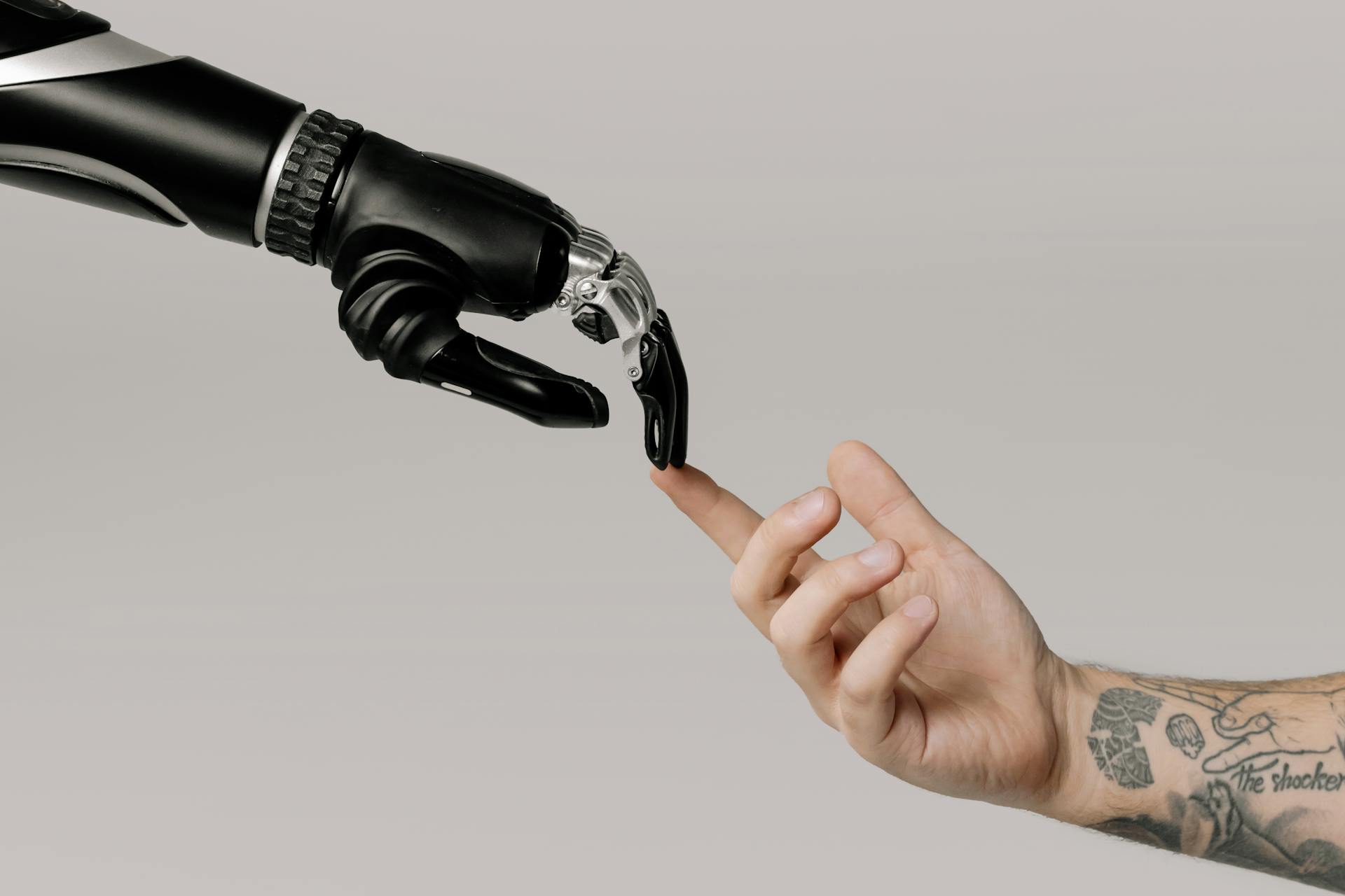 Robotic hand reaches out to touch the hand of a person.