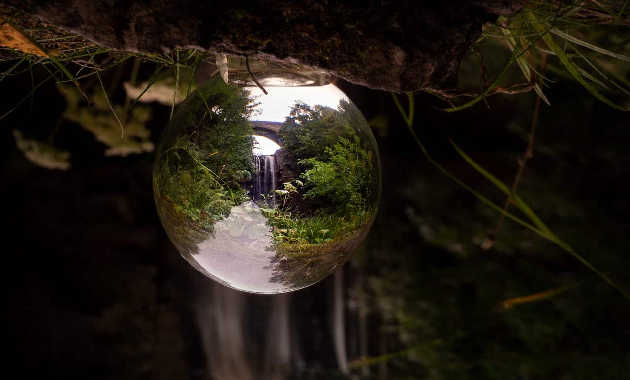 Waterfall reflected inside of a crystal ball that looks like a large water droplet
