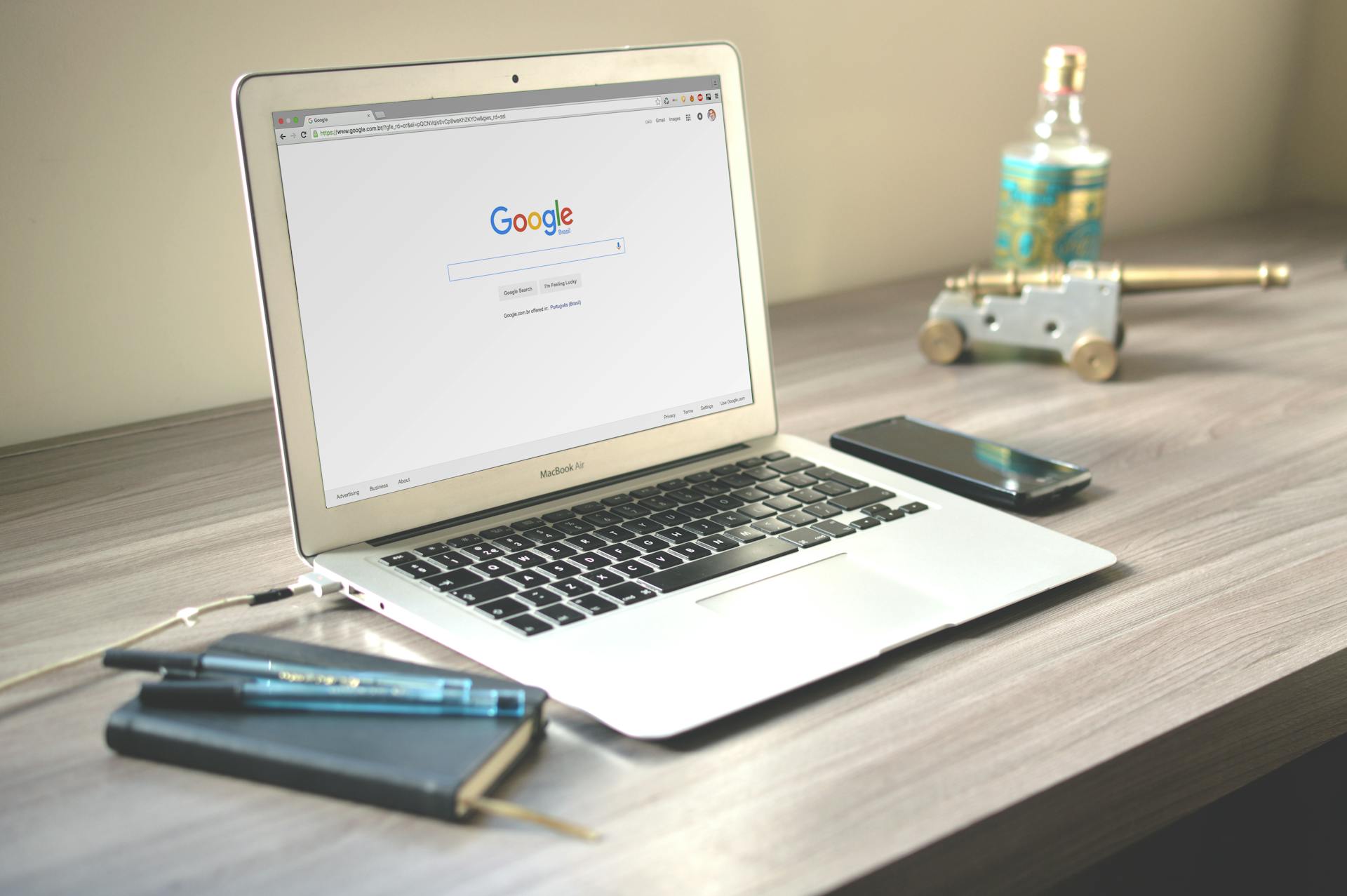 Laptop with Google open on the screen with office supplies surrounding it.