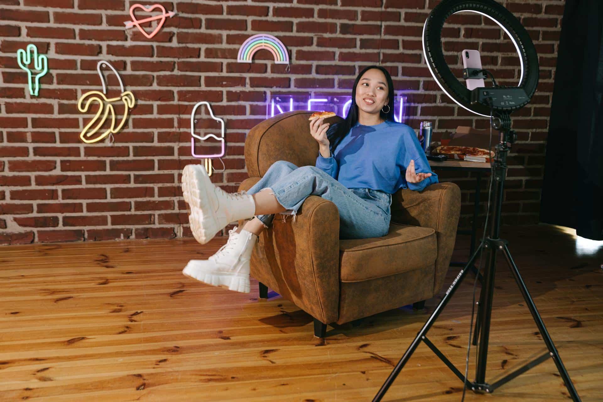 Relaxed woman leans sideways in armchair talking to a camera.