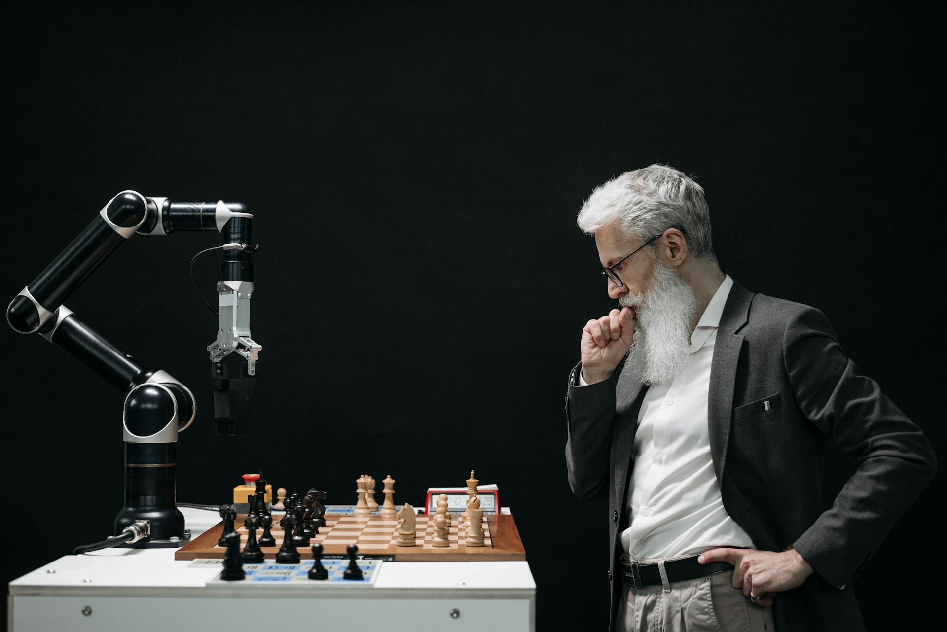 Man playing against chess robot considers his next move