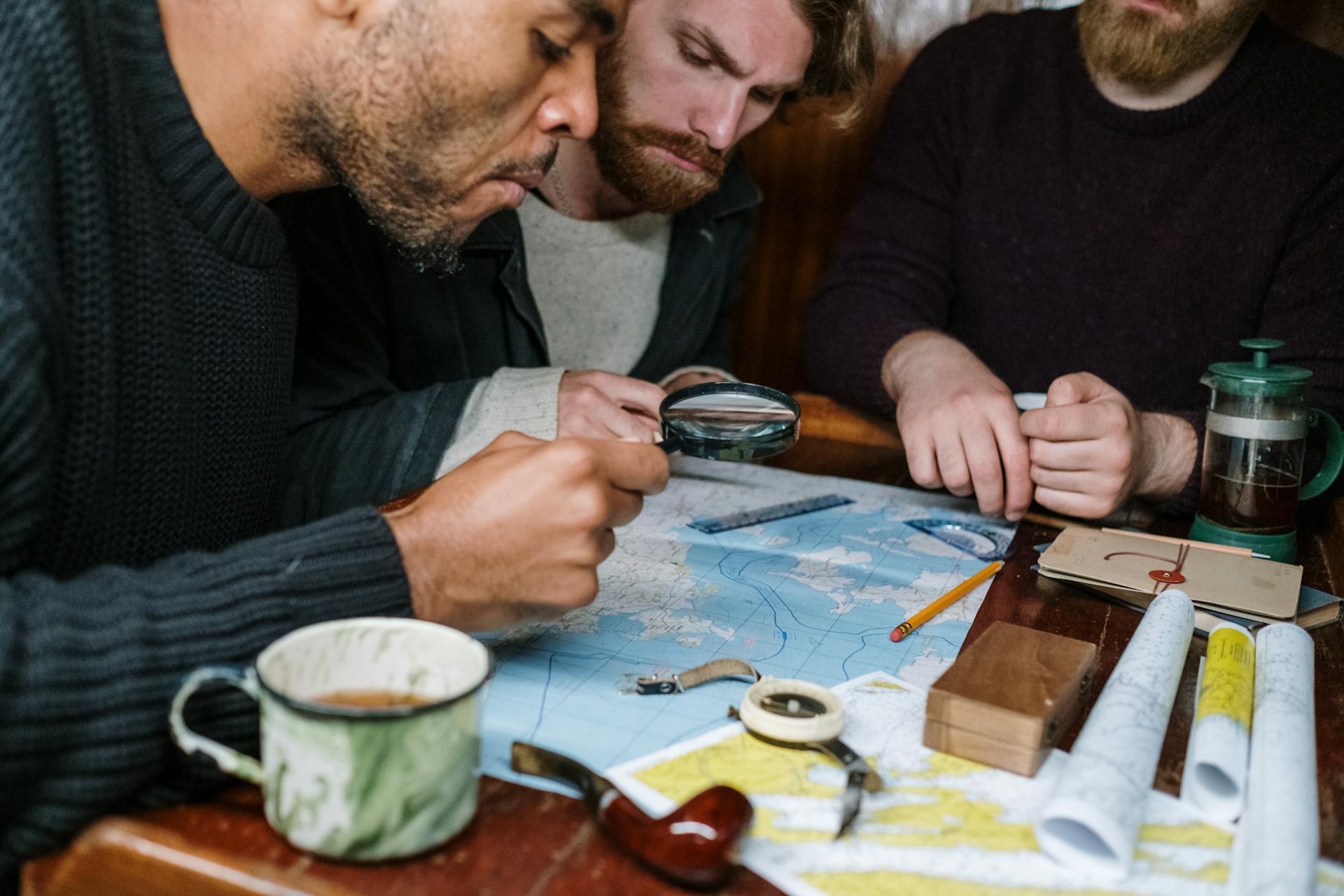 Three people crowd around and scrutinize a map.
