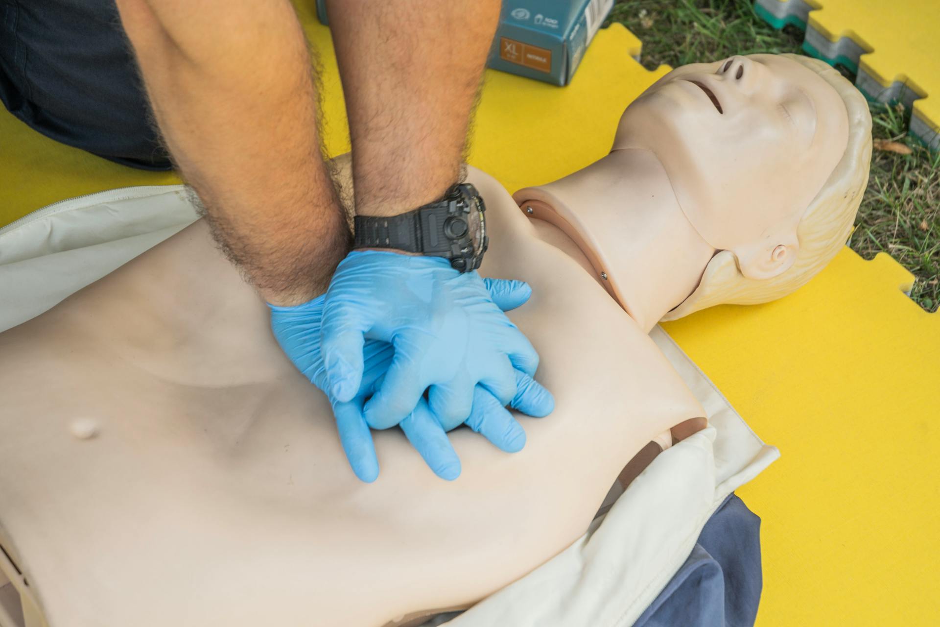 Image of a CPR dummy with hands pressing onto the chest.