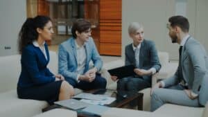 Group of working professionals organized around a table conversing