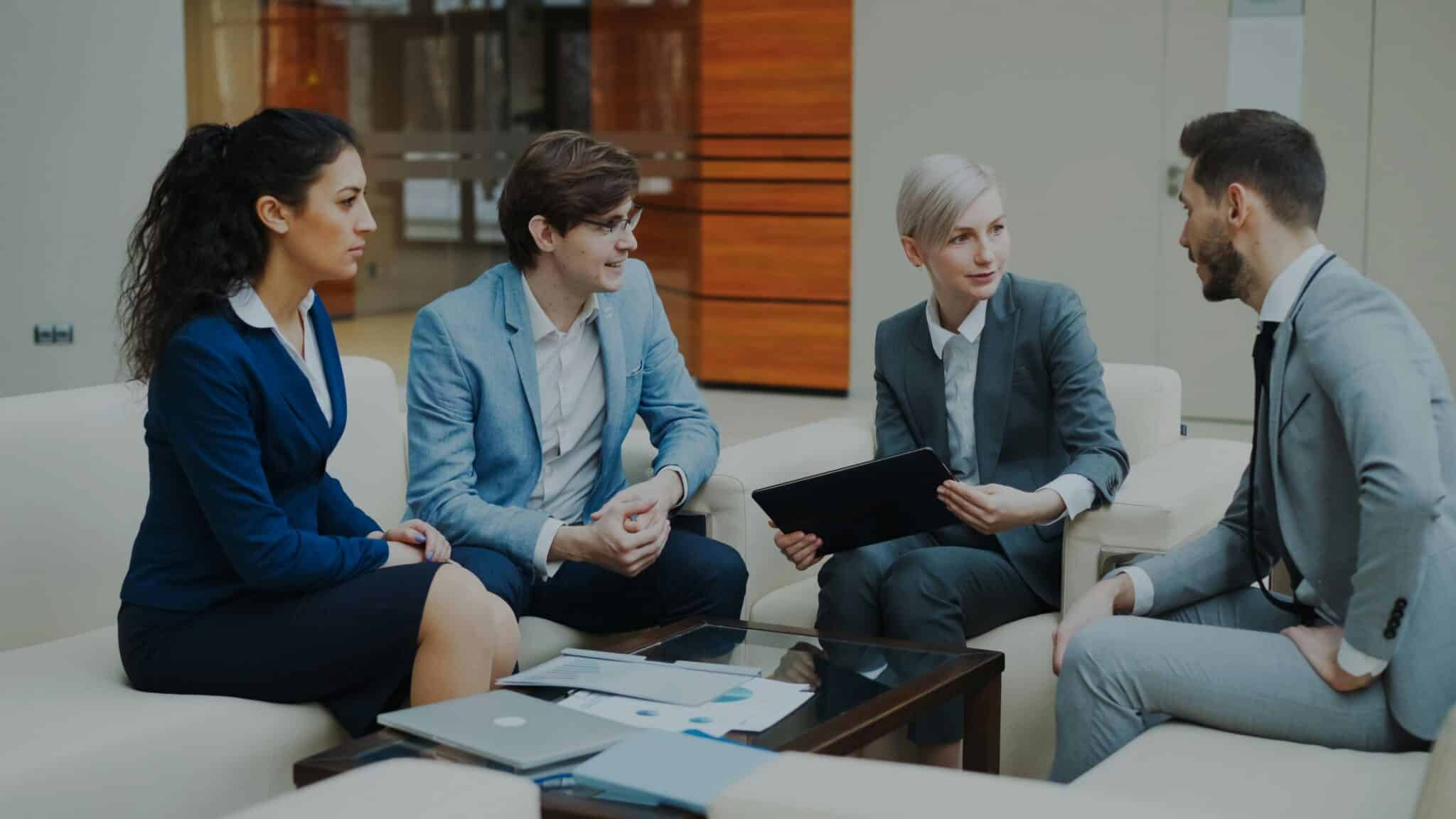 Group of working professionals organized around a table conversing
