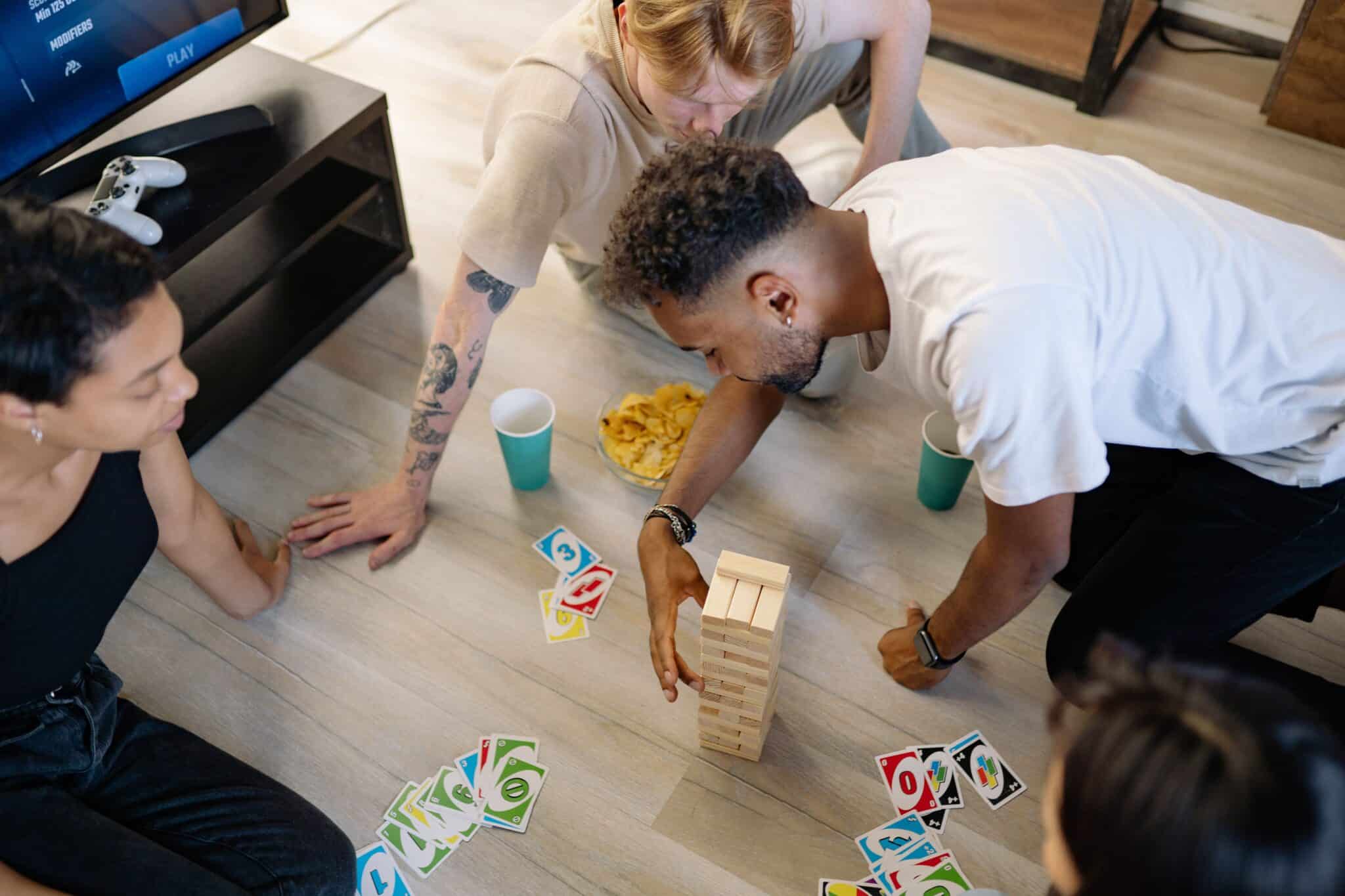 Three people playing board games on the floor