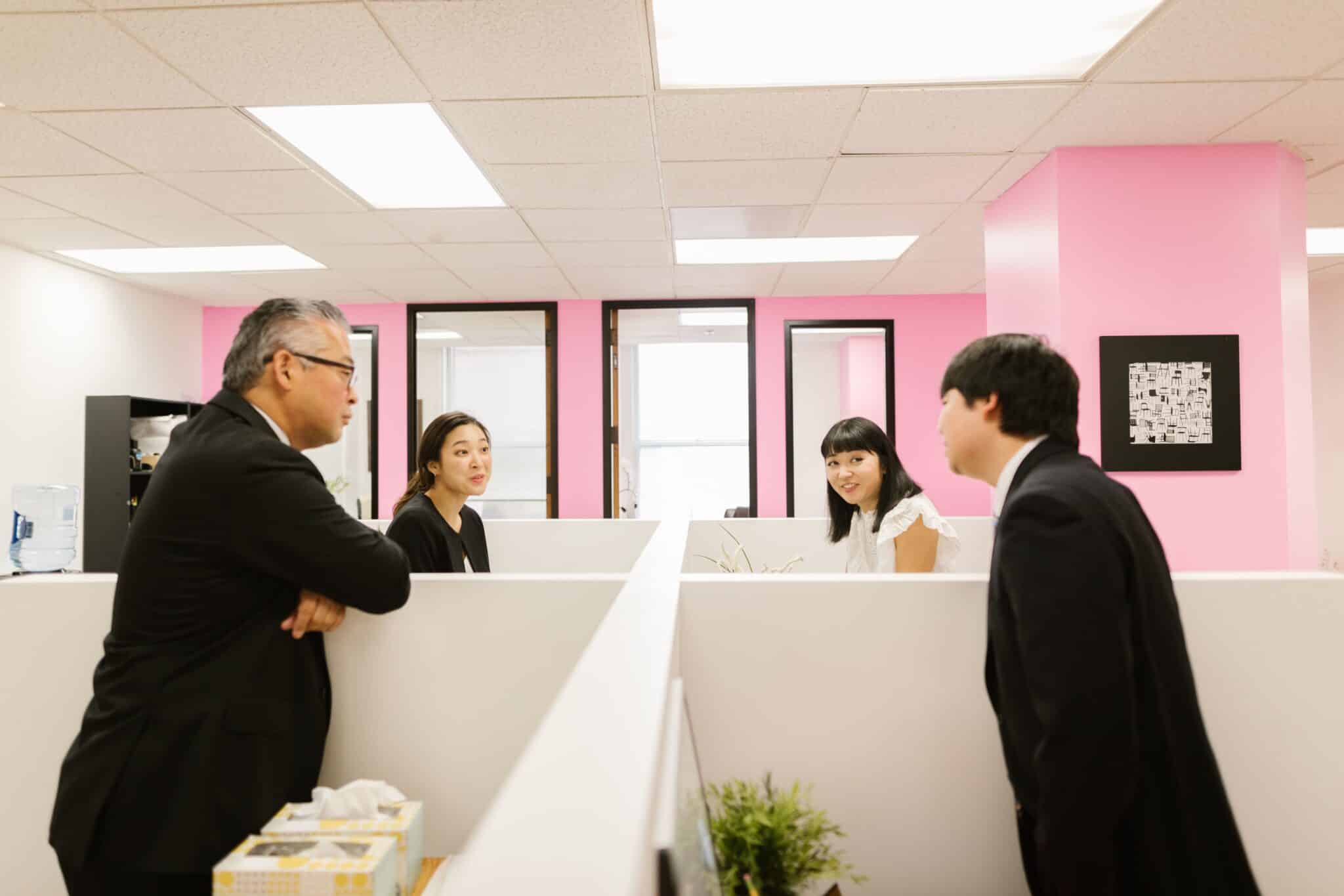 Group of people talking over a cubicle