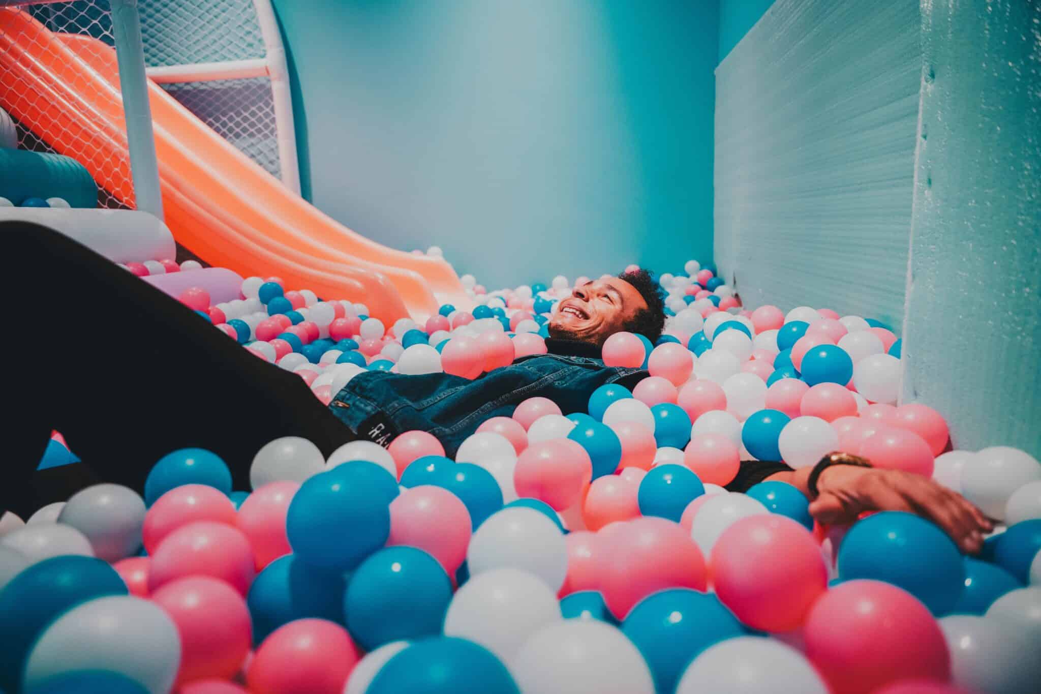 Man laying in a ball pit