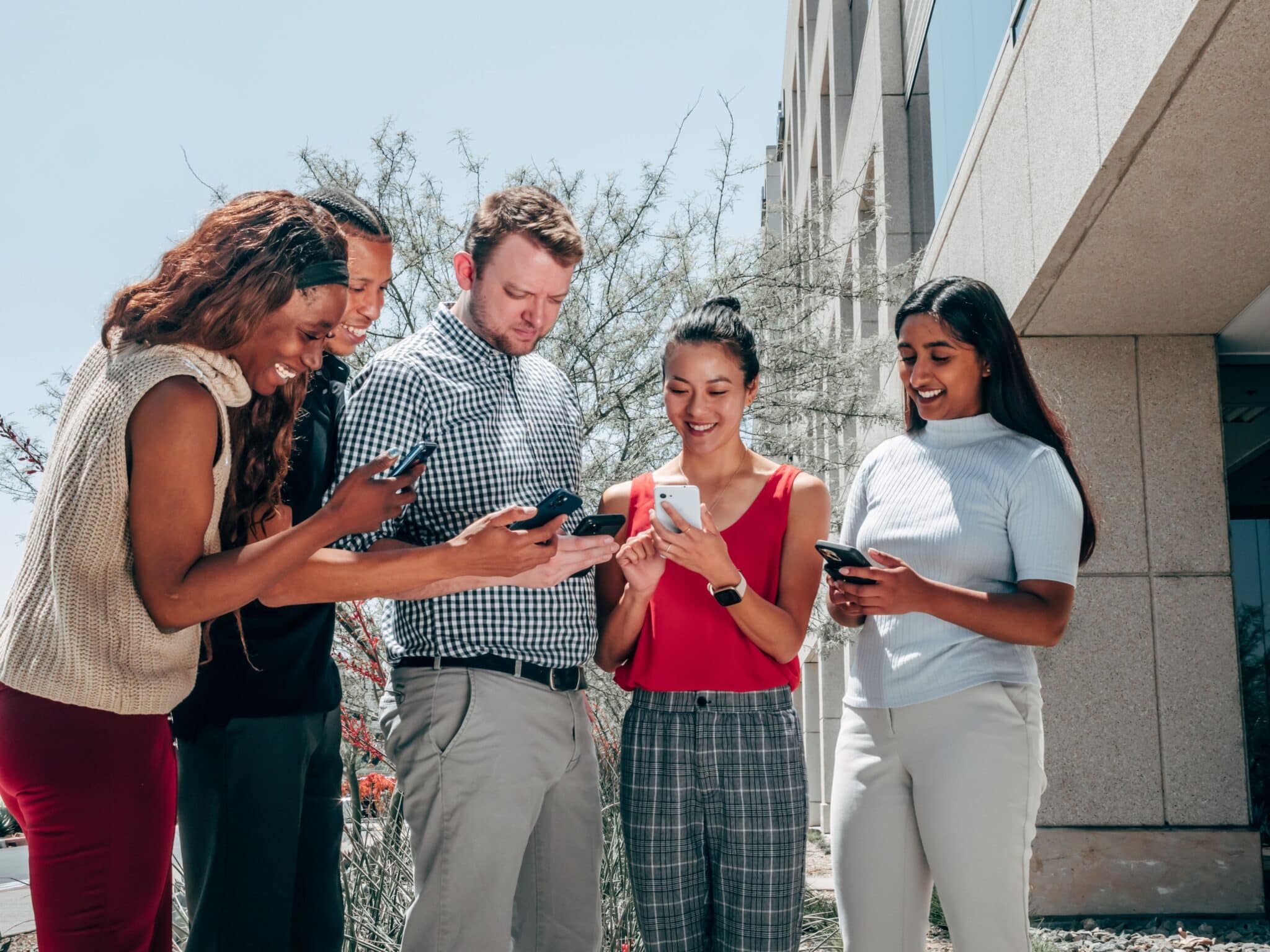 A group of people using their cell phone