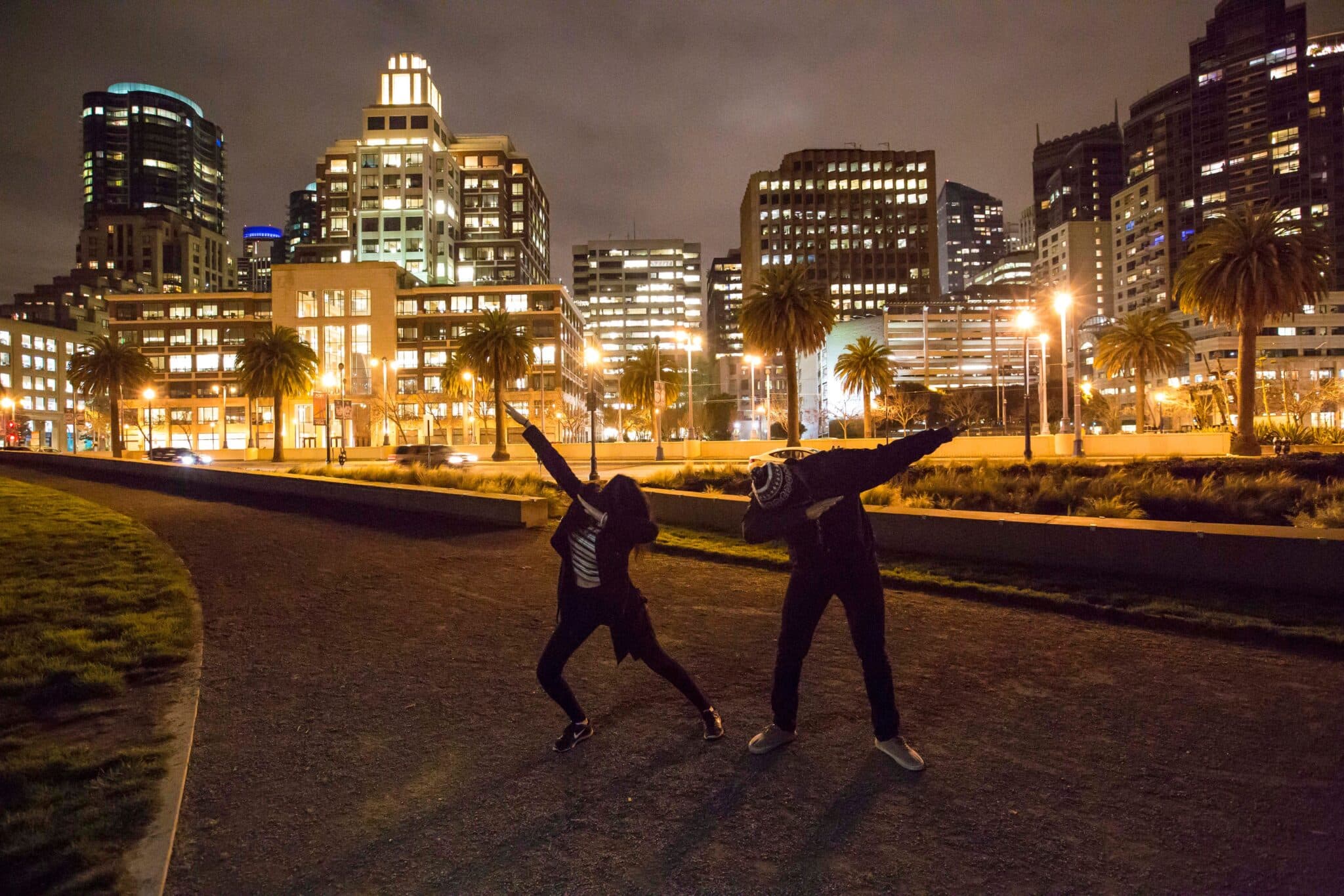 Two people dancing in a park at night