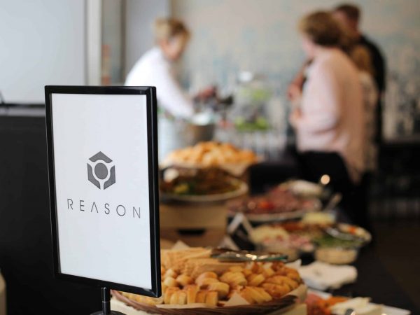 nice shot of reason logo with catering and food and drinks being served